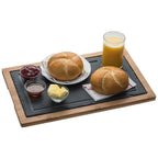 Servierbrett aus Bambus mit Schieferplatte gedeckt mit Brötchen, Butter, Konfitüre und Orangensaft